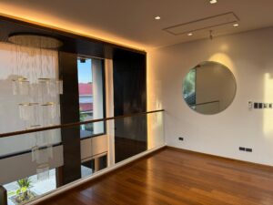 Modern staircase landing with designer chandelier and large vertical windows
